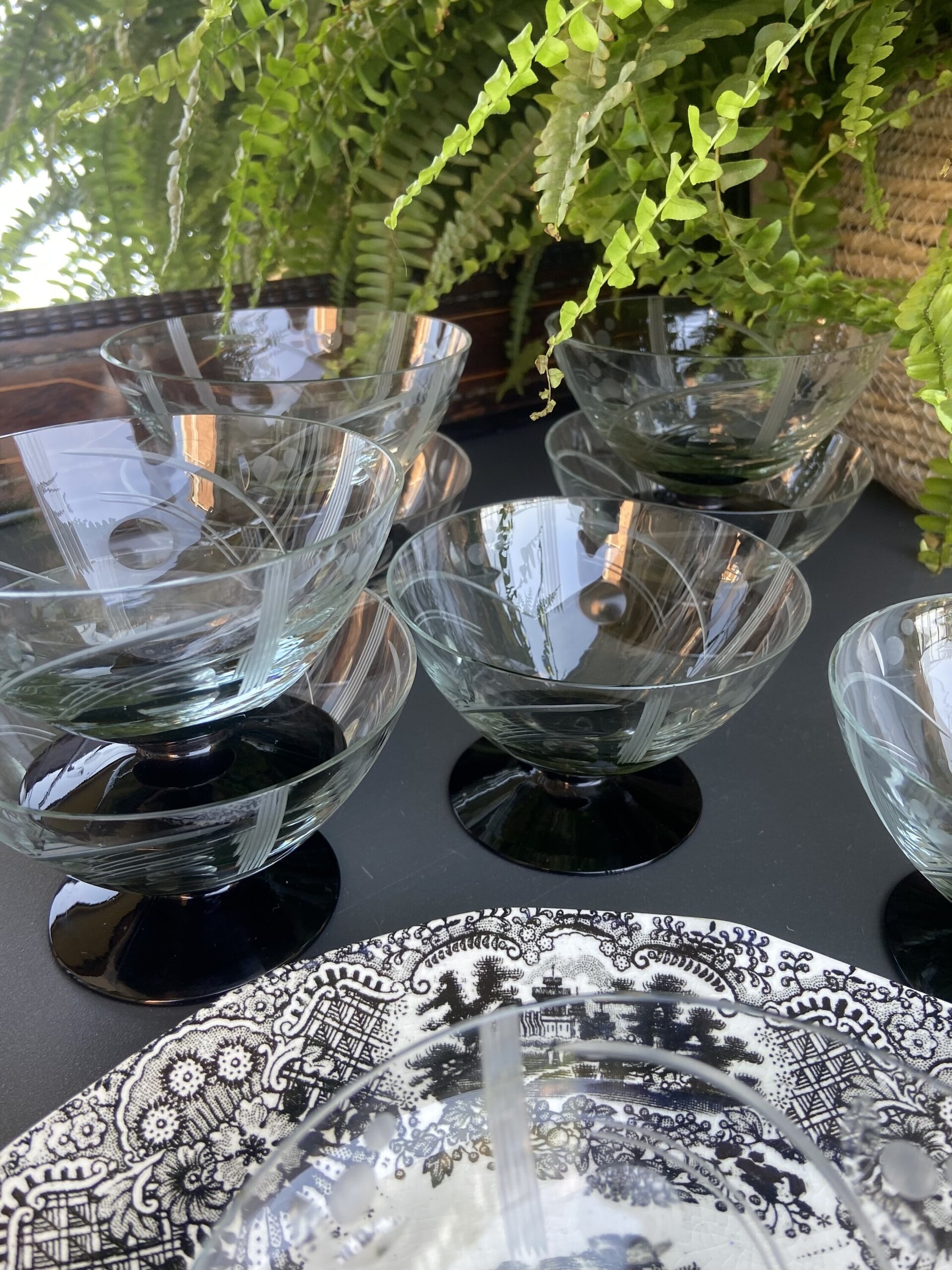 9 copas en vidrio tallado transparente con pie negro. - 1